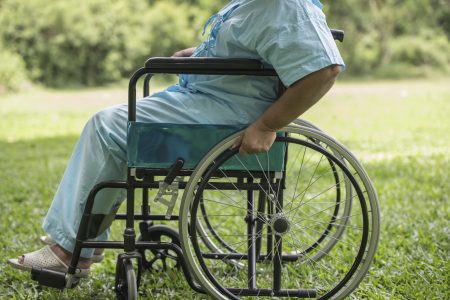 Close up Lonely elderly woman sitting on wheelchair at garden in hospital
